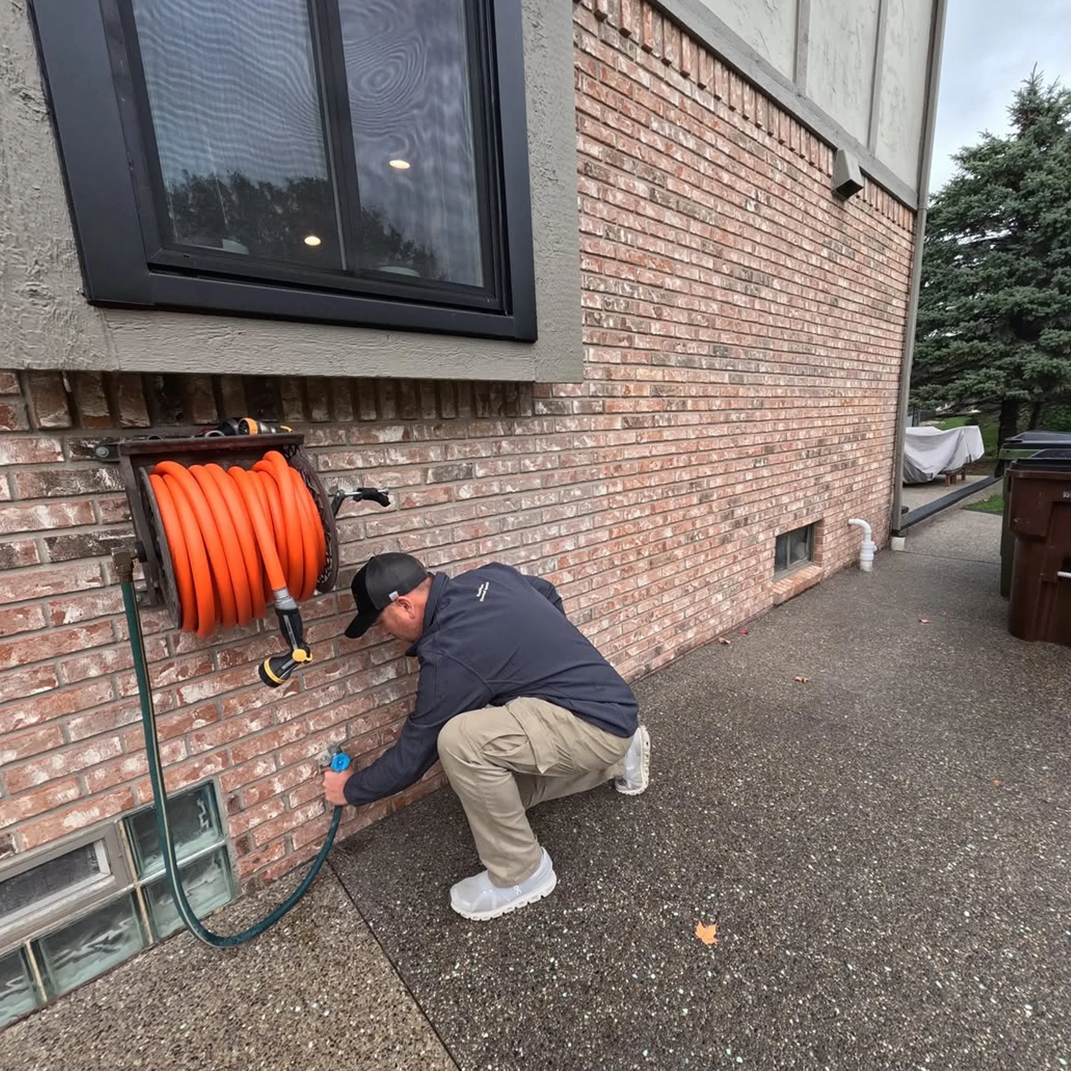 person working on exterior hose connection